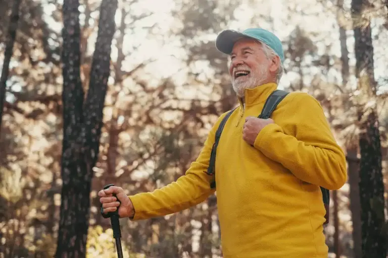 “Active senior man hiking in the woods, enjoying nature and outdoor exercise.”